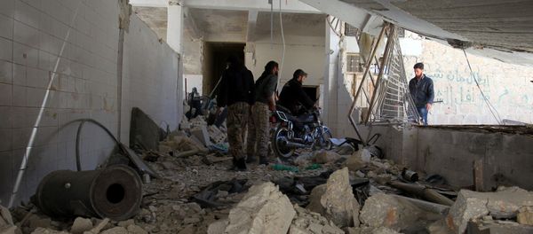 Men salvage a motorbike amid the damage inside a medical point at a site hit by airstrikes on Tuesday, in the town of Khan Sheikhoun in Idlib, Syria April 5, 2017 - Sputnik International