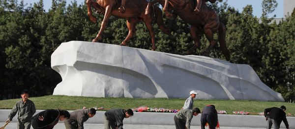 People sweep in front of statues of former North Korean leaders Kim Il Sung and Kim Jong Il in central Pyongyang, North Korea April 12, 2017. - Sputnik International