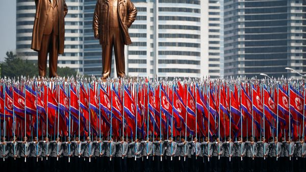 People carry flags in front of statues of North Korea founder Kim Il Sung (L) and late leader Kim Jong Il during a military parade marking the 105th birth anniversary Kim Il Sung, in Pyongyang April 15, 2017. People carry flags in front of statues of North Korea founder Kim Il Sung (L) and late leader Kim Jong Il during a military parade marking the 105th birth anniversary Kim Il Sung, in Pyongyang April 15, 2017. - Sputnik International