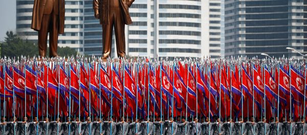People carry flags in front of statues of North Korea founder Kim Il Sung (L) and late leader Kim Jong Il during a military parade marking the 105th birth anniversary Kim Il Sung, in Pyongyang April 15, 2017. People carry flags in front of statues of North Korea founder Kim Il Sung (L) and late leader Kim Jong Il during a military parade marking the 105th birth anniversary Kim Il Sung, in Pyongyang April 15, 2017. - Sputnik International