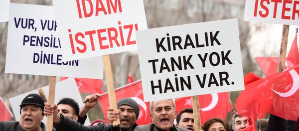 Turkish protestors chant slogans and a man (C) holds a placard reading ''We want death penalty'' as former Turkish soldiers (not pictured), accused of trying to assassinate Turkish President during the July coup attempt, are escorted by Turkish soldiers towards the courthouse in Mugla, western Turkey, on February 20, 2017 - Sputnik International