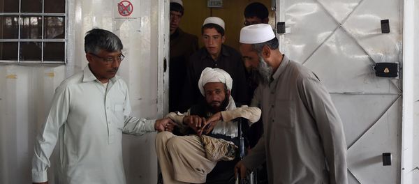 Afghan refugees help a disabled refugee at the United Nations High Commissioner for Refugees (UNHCR) repatriation centre on the outskirts of Peshawar on April 11, 2017, as they prepare to return to their home country after fleeing civil war and Taliban rule Afghan refugees help a disabled refugee at the United Nations High Commissioner for Refugees (UNHCR) repatriation centre on the outskirts of Peshawar on April 11, 2017, as they prepare to return to their home country after fleeing civil war and Taliban rule - Sputnik International