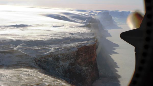 Snow from the neighboring plateau falling onto the windswept east wall of the Petermann Glacier. Snow from the neighboring plateau falling onto the windswept east wall of the Petermann Glacier. - Sputnik International