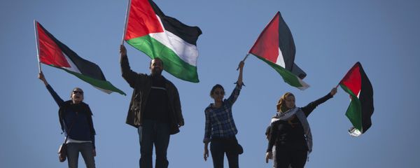 Palestinians wave national flags during a protest - Sputnik International