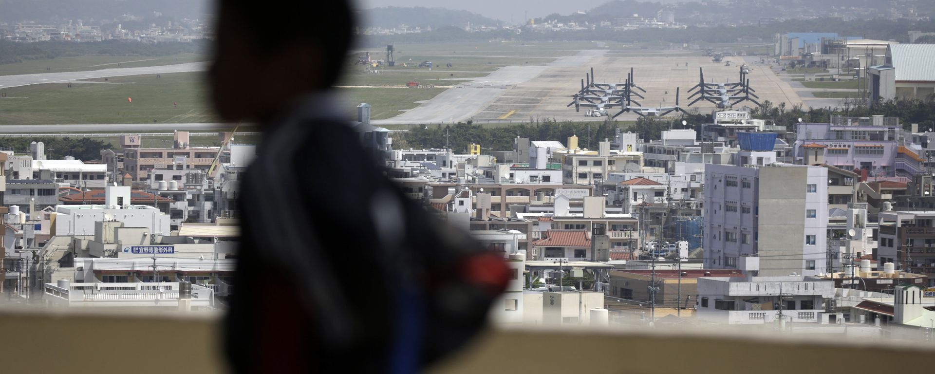 A child looks at the U.S. Marine Corps Futenma Air Station and the surrounding area from an observation deck at a park in Ginowan, Okinawa Prefecture on southern Japan. - Sputnik International, 1920, 19.11.2017