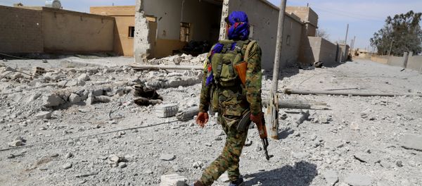 A member of the US-backed Syrian Democratic Forces (SDF), made up of an alliance of Arab and Kurdish fighters, patrols in the town of Al-Karamah, 26 kms from the Islamic State (IS) group bastion of Raqa, as they advance to encircle the jihadists, on March 26, 2017 A member of the US-backed Syrian Democratic Forces (SDF), made up of an alliance of Arab and Kurdish fighters, patrols in the town of Al-Karamah, 26 kms from the Islamic State (IS) group bastion of Raqa, as they advance to encircle the jihadists, on March 26, 2017 - Sputnik International