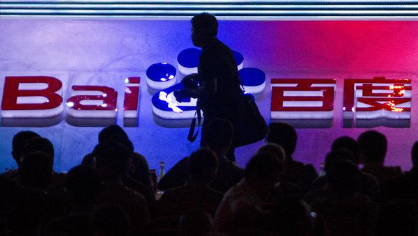 FILE - In this Sept. 2, 2011 file photo, a photographer walks past the logo of Baidu Inc., which operates China's dominant search engine, during a technology innovation conference held by the company at China's National Convention Center in Beijing, China. China issued new regulations on Saturday, June 25, 2016 demanding search engines clearly identify paid search results, months after a terminally-ill cancer patient complained that he was misled by the giant search engine Baidu. - Sputnik International