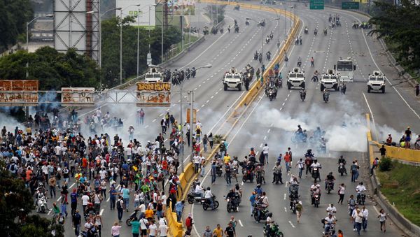 Demonstrators run away from tear gas during clashes with police while rallying against Venezuela's President Nicolas Maduro in Caracas, Venezuela, April 20, 2017. Demonstrators run away from tear gas during clashes with police while rallying against Venezuela's President Nicolas Maduro in Caracas, Venezuela, April 20, 2017. - Sputnik International