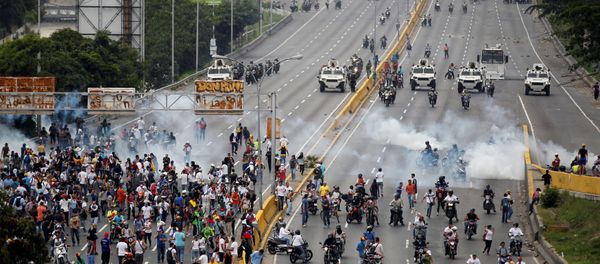 Demonstrators run away from tear gas during clashes with police while rallying against Venezuela's President Nicolas Maduro in Caracas, Venezuela, April 20, 2017. Demonstrators run away from tear gas during clashes with police while rallying against Venezuela's President Nicolas Maduro in Caracas, Venezuela, April 20, 2017. - Sputnik International