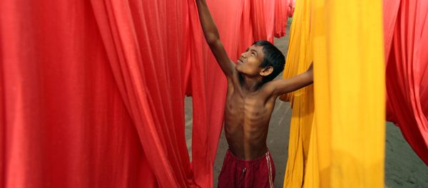 In this Saturday, Dec. 22, 2012 file photo, a Bangladeshi child works at a clothes-dyeing factory in Narayanganj, outskirts of Dhaka, Bangladesh. - Sputnik International