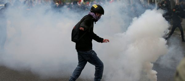A protester kicks back a tear gas grenade during a demonstration for a social first round on the eve of the first round in the French presidential election, in Paris, France - Sputnik International