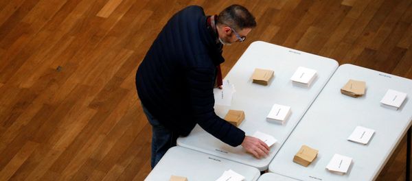 A man choose his ballots before voting in the first round of 2017 French presidential election at a polling station in Lyon, France, April 23, 2017. - Sputnik International