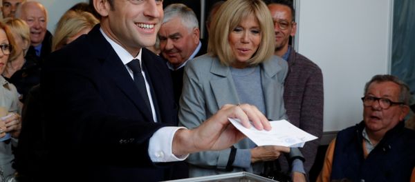 Emmanuel Macron (L), head of the political movement En Marche !, or Onwards !, and candidate for the 2017 French presidential election, casts his ballot in the first round of 2017 French presidential election at a polling station in Le Touquet, northern France, April 23, 2017. At C, his wife Brigitte Trogneux. Emmanuel Macron (L), head of the political movement En Marche !, or Onwards !, and candidate for the 2017 French presidential election, casts his ballot in the first round of 2017 French presidential election at a polling station in Le Touquet, northern France, April 23, 2017. At C, his wife Brigitte Trogneux. - Sputnik International