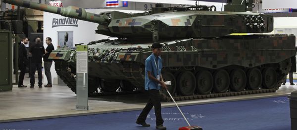 A cleaner sweeps the floor in front of a Rheinmetall MBT tank at the International Defense Exhibition and Conference, known by the acronym IDEX, in Abu Dhabi, United Arab Emirates, Sunday, Feb. 19, 2017 A cleaner sweeps the floor in front of a Rheinmetall MBT tank at the International Defense Exhibition and Conference, known by the acronym IDEX, in Abu Dhabi, United Arab Emirates, Sunday, Feb. 19, 2017 - Sputnik International