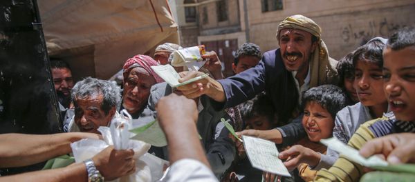 Yemenis receive food rations provided by a local charity, in Sanaa, Yemen, Thursday, April, 13, 2017. - Sputnik International