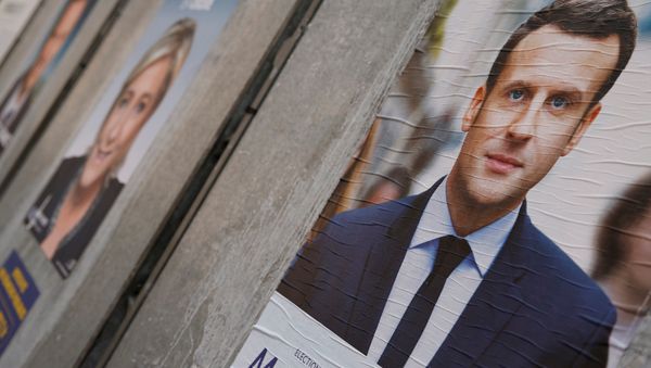 People walk past campaign posters of Emmanuel Macron (L), head of the political movement En Marche! (Onwards!), and Marine Le Pen (R), French National Front (FN) political party leader, two of the eleven candidates who run in the 2017 French presidential election, are seen in Paris, France, April 10, 2017 People walk past campaign posters of Emmanuel Macron (L), head of the political movement En Marche! (Onwards!), and Marine Le Pen (R), French National Front (FN) political party leader, two of the eleven candidates who run in the 2017 French presidential election, are seen in Paris, France, April 10, 2017 - Sputnik International