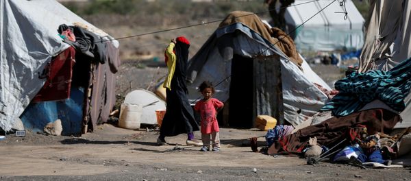A woman walks past a child at a camp for people displaced by the war, near Sanaa, Yemen April 25, 2017 - Sputnik International