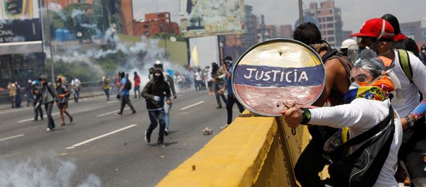 Opposition supporters use a shield reading Justice as they clash with security forces during a rally against Venezuela's President Nicolas Maduro in Caracas, Venezuela April 26, 2017 Opposition supporters use a shield reading Justice as they clash with security forces during a rally against Venezuela's President Nicolas Maduro in Caracas, Venezuela April 26, 2017 - Sputnik International