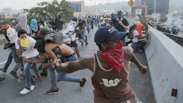 Anti-government protesters throw stones from a highway overpass at a passing police patrol in Caracas, Venezuela, Monday, April 24, 2017 Anti-government protesters throw stones from a highway overpass at a passing police patrol in Caracas, Venezuela, Monday, April 24, 2017 - Sputnik International