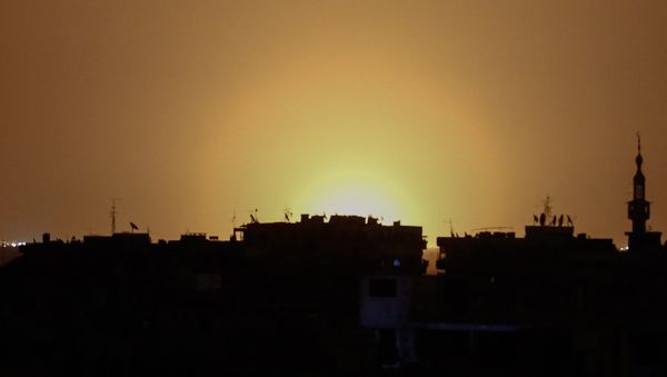 A photo taken from the rebel-held town of Douma shows flames rising in the distance which are believed to be coming from Damascus International Airport following an explosion early in the morning of April 27, 2017 - Sputnik International