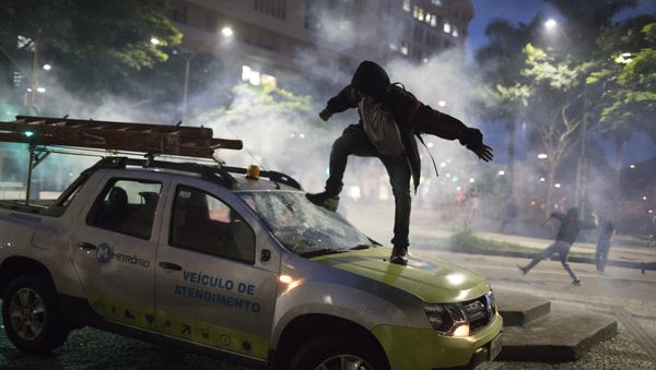 A demonstrator breaks the windshield of a truck that belongs to a subway maintenance crew after clashes with police broke out during a general strike in Rio de Janeiro, Brazil, Friday, April 28, 2017. A demonstrator breaks the windshield of a truck that belongs to a subway maintenance crew after clashes with police broke out during a general strike in Rio de Janeiro, Brazil, Friday, April 28, 2017. - Sputnik International