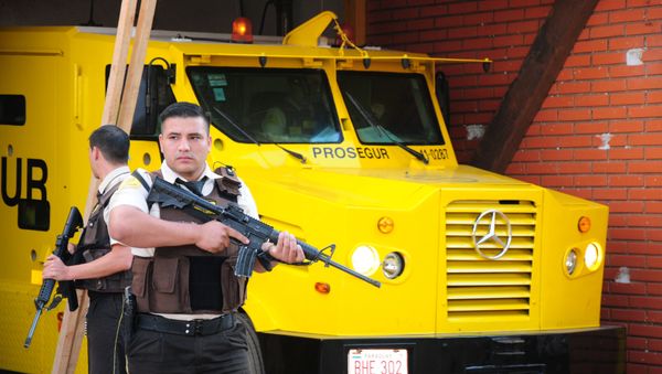 Security personnel stand guard next to an armored truck of private security company Prosegur after a gang of robbers carried out an assault on Monday with explosives and robbing millions of dollars, in Ciudad del Este, Paraguay April 25, 2017. - Sputnik International