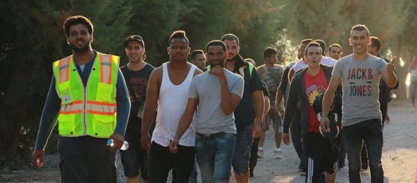 Refugees helping other refugees find safety. Refugees helping other refugees find safety. - Sputnik International