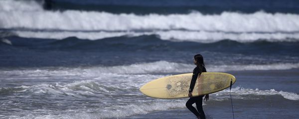 A surfer strolls into the waves at Cardiff State Beach in Encinitas, Calif. A surfer strolls into the waves at Cardiff State Beach in Encinitas, Calif. - Sputnik International