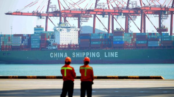 Chinese workers stand on a pier before a cargo ship at a port in Qingdao, east China's Shandong province on April 13, 2017 - Sputnik International