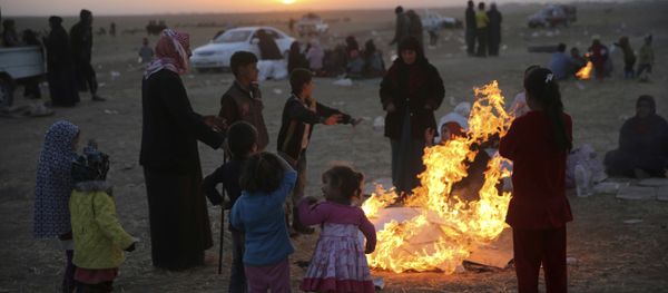In this Thursday, Nov. 17, 2016 photo, Iraqis, who fled the fighting between Iraqi forces and Islamic State militants, gather around flames to warm themselves from the cold, as they wait to cross to the Kurdish controlled area, in the Nineveh plain, northeast of Mosul In this Thursday, Nov. 17, 2016 photo, Iraqis, who fled the fighting between Iraqi forces and Islamic State militants, gather around flames to warm themselves from the cold, as they wait to cross to the Kurdish controlled area, in the Nineveh plain, northeast of Mosul - Sputnik International