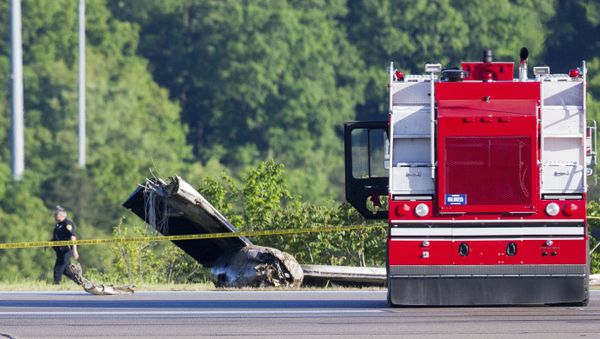 An officer walks near part of a cargo plane following a fatal crash at Yeager Airport in Charleston, W. Va., Friday, May 5, 2017 - Sputnik International