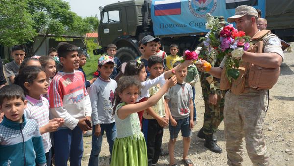 Children in the village of Brabishbo, Syria greet Russian servicemen with flowers and citrus fruit - Sputnik International