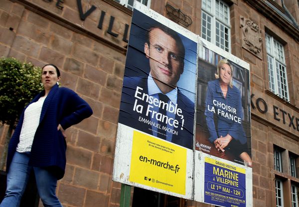 A woman walks near election campaign posters for French centrist presidential candidate Emmanuel Macron, left, and far-right candidate Marine Le Pen, in Saint Jean Pied de Port, southwestern France, Friday May 5, 2017 - Sputnik International