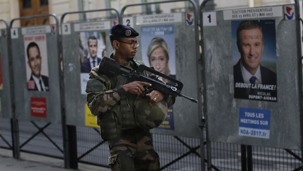 An army soldier patrols past posters showing faces of the candidates for the first-round presidential election near a polling station in Paris, Sunday, April 23, 2017 An army soldier patrols past posters showing faces of the candidates for the first-round presidential election near a polling station in Paris, Sunday, April 23, 2017 - Sputnik International
