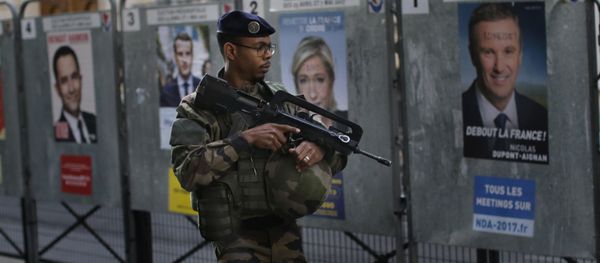 An army soldier patrols past posters showing faces of the candidates for the first-round presidential election near a polling station in Paris, Sunday, April 23, 2017 An army soldier patrols past posters showing faces of the candidates for the first-round presidential election near a polling station in Paris, Sunday, April 23, 2017 - Sputnik International