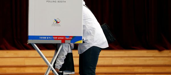 A voter and her son are seen at a polling station during the presidential elections in Seoul, South Korea May 9, 2017. - Sputnik International