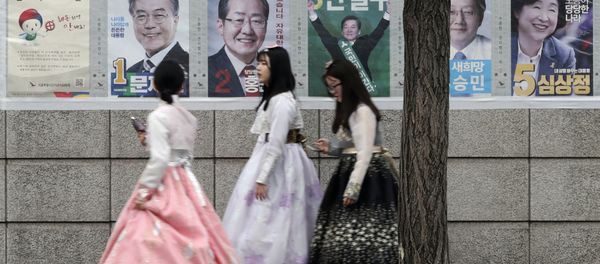 Women walk by posters showing candidates for the presidential election in Seoul, South Korea, Tuesday, May 9, 2017. - Sputnik International