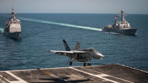 An F/A-18E Super Hornet lands on the flight deck of the U.S. Navy aircraft carrier USS Carl Vinson as the Ticonderoga-class guided-missile cruiser USS Lake Champlain (L) and the Arleigh Burke-class guided-missile destroyer USS Wayne E. Meyer transit the western Pacific Ocean May 3, 2017. - Sputnik International