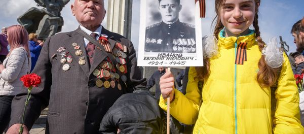 A World War II veteran and a girl attend festivities at the Victory Monument as Latvia's large Russian minority marks 72 years since the end of World War II and commemorates the Soviet victory over Nazi Germany in Riga, Latvia - Sputnik International
