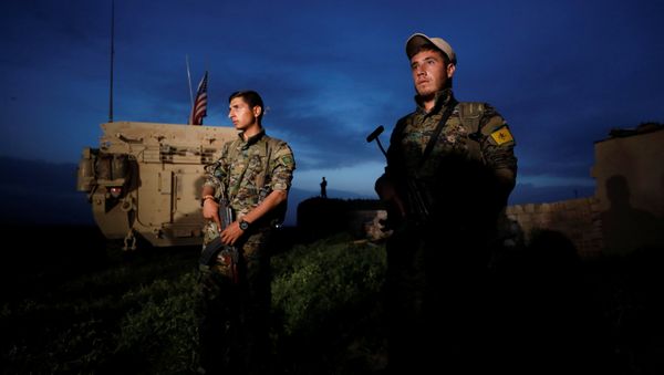 Kurdish fighters from the People's Protection Units (YPG) stand near a US military vehicle in the town of Darbasiya next to the Turkish border, Syria April 28, 2017. - Sputnik International