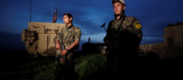 Kurdish fighters from the People's Protection Units (YPG) stand near a US military vehicle in the town of Darbasiya next to the Turkish border, Syria April 28, 2017. - Sputnik International