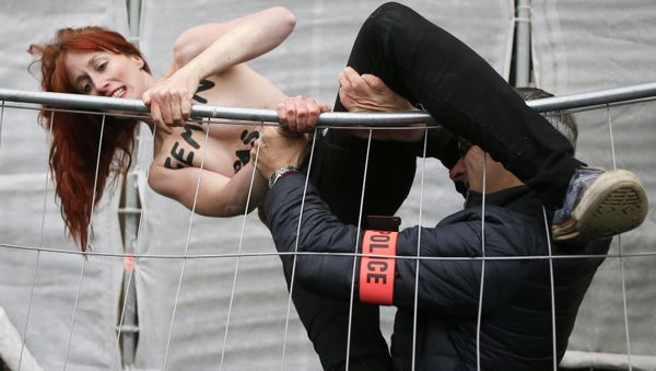 Полиция ловит активистку Femen, протестующую против партии Марин Ле Пен, Франция - Sputnik International