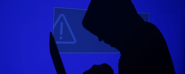 A hooded man holds a laptop computer as blue screen with an exclamation mark is projected on him in this illustration picture taken on May 13, 2017 A hooded man holds a laptop computer as blue screen with an exclamation mark is projected on him in this illustration picture taken on May 13, 2017 - Sputnik International