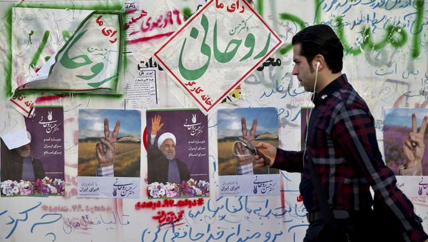 In this Wednesday, May 10, 2017 photo, an Iranian man walks past electoral posters and hand written slogans for presidential election candidates in downtown Tehran, Iran In this Wednesday, May 10, 2017 photo, an Iranian man walks past electoral posters and hand written slogans for presidential election candidates in downtown Tehran, Iran - Sputnik International