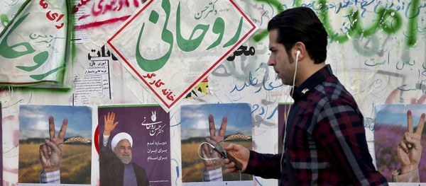 In this Wednesday, May 10, 2017 photo, an Iranian man walks past electoral posters and hand written slogans for presidential election candidates in downtown Tehran, Iran - Sputnik International