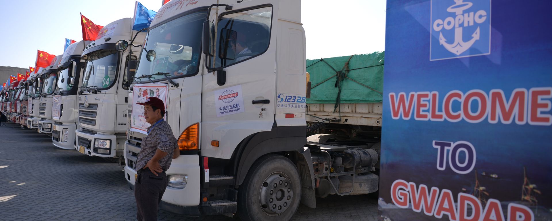 A Chinese worker stands near trucks carrying goods during the opening of a trade project in Gwadar port, some 700 kms west of the Pakistani city of Karachi on November 13, 2016. A Chinese worker stands near trucks carrying goods during the opening of a trade project in Gwadar port, some 700 kms west of the Pakistani city of Karachi on November 13, 2016. - Sputnik International, 1920, 13.04.2026