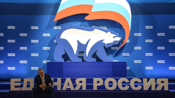 A man is seen here sitting next to a stand with United Russia symbols (File) - Sputnik International