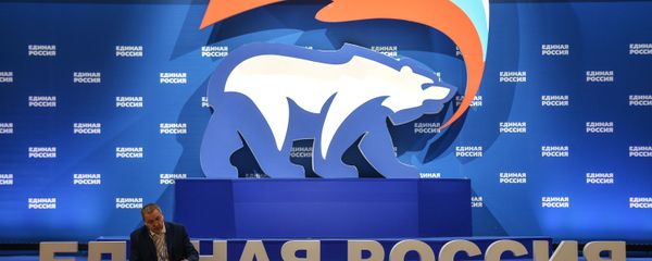 A man is seen here sitting next to a stand with United Russia symbols (File) - Sputnik International