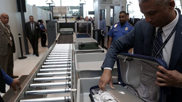 A TSA official removes a laptop from a bag for scanning using the Transport Security Administration's new Automated Screening Lane technology at Terminal 4 of JFK airport in New York City, U.S., May 17, 2017 - Sputnik International