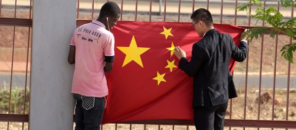 A Senegalese worker and a Chinese man put a Chinese flag in Diamniadio district in Dakar on May 7, 2017 during the visit of Chinese vice president Li Yuanchao (not seen) A Senegalese worker and a Chinese man put a Chinese flag in Diamniadio district in Dakar on May 7, 2017 during the visit of Chinese vice president Li Yuanchao (not seen) - Sputnik International